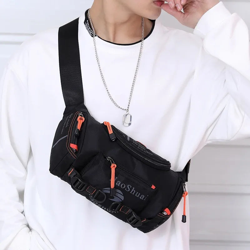 A person wearing a white sweatshirt holds a black tactical chest bag with orange accents and a silver necklace.