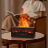A black fireplace molding device is shown emitting bright orange flames on a wooden table.