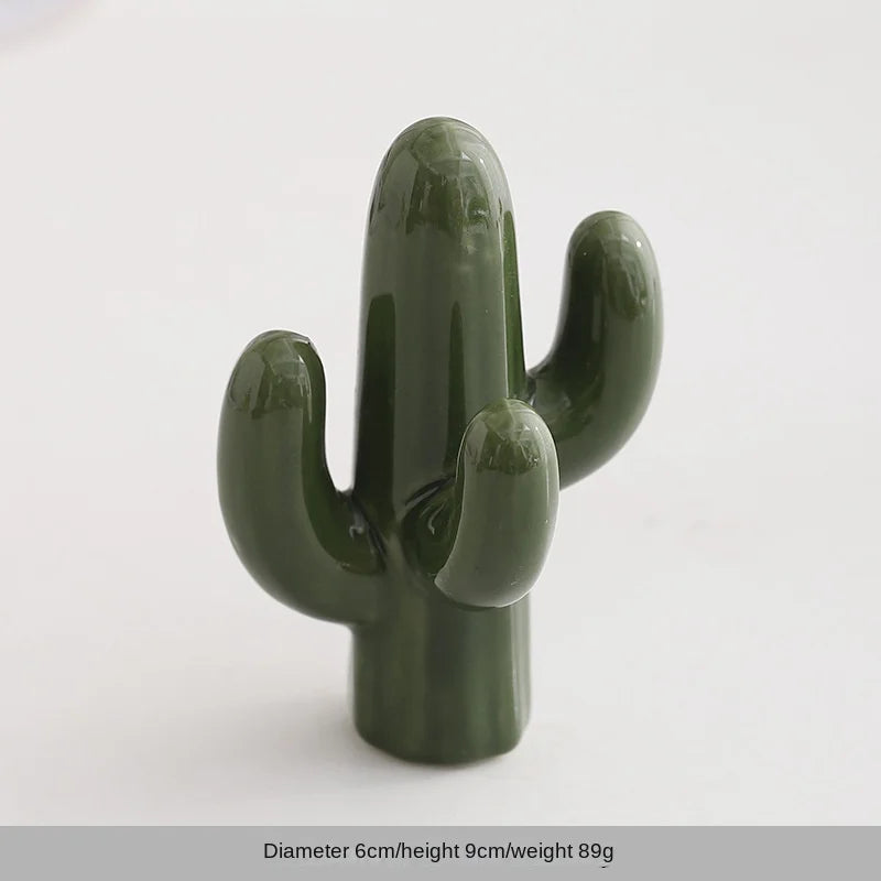 A handcrafted ceramic elephant and rabbit jewelry holder with a smooth, olive green finish.