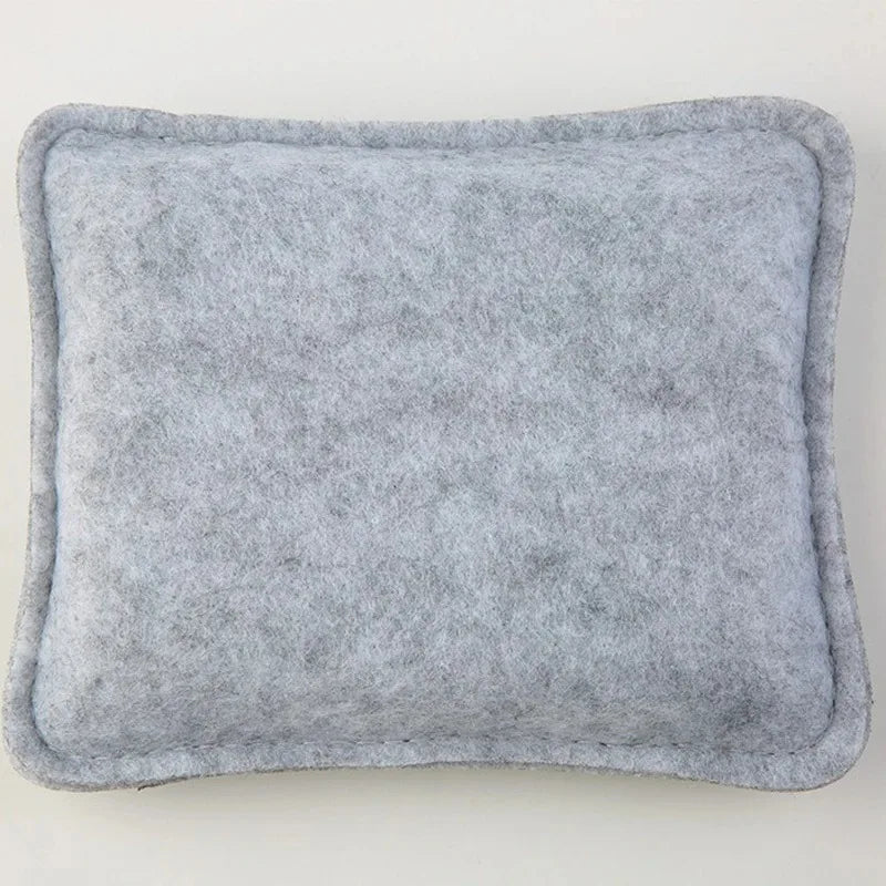 A square, gray needle felting mat made of wool for crafting.