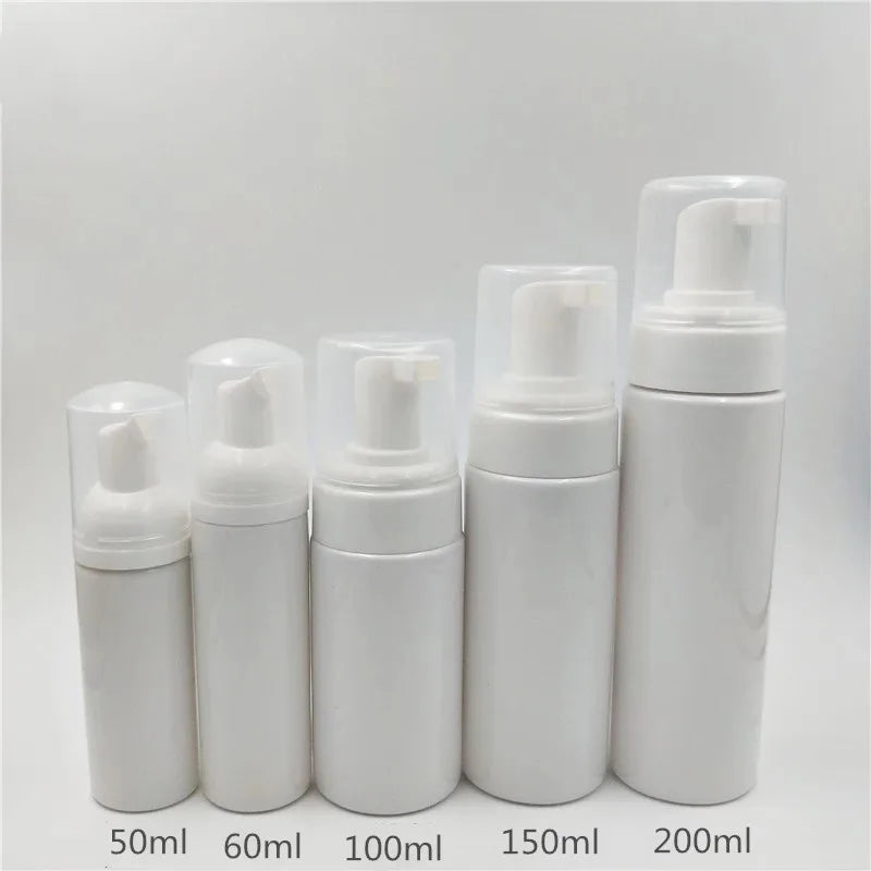 A row of white refillable foaming soap dispenser bottles in various sizes from 50ml to 200ml.