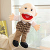 A cartoon-style hand puppet featuring a white beard, red mouth, and plaid shirt, standing in a light indoor setting.
