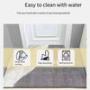A minimalist geometric non-slip absorbent rug placed on a gray floor with cleaning methods illustrated.