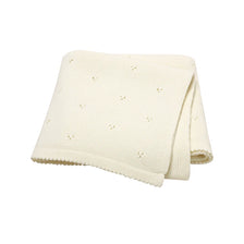 A cream-colored, knitted soft cotton baby blanket with small holes for breathability.