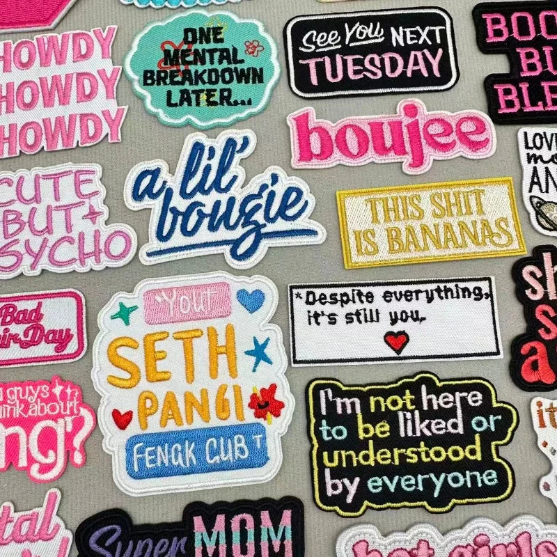 A collection of colorful cartoon embroidered iron-on patches featuring text like One Mental Breakdown Later and This Shit Is 