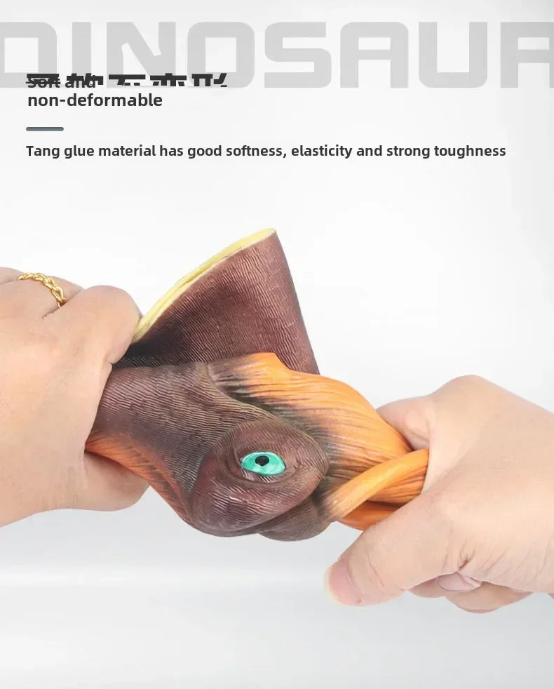 A hand is holding a realistic dinosaur hand puppet toy with textured skin and an eye detail.