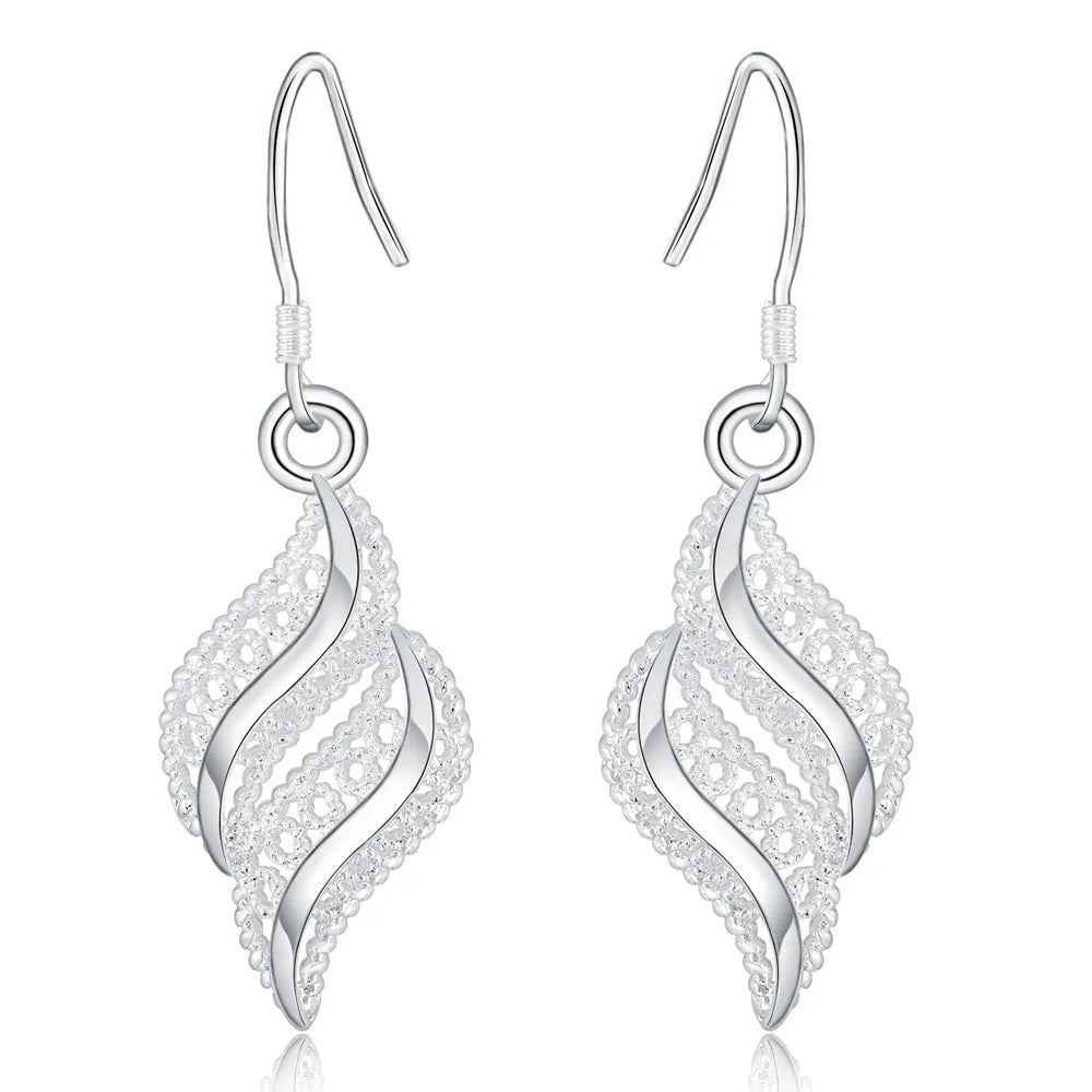 Pair of vintage sterling silver dangle earrings with a swirling design