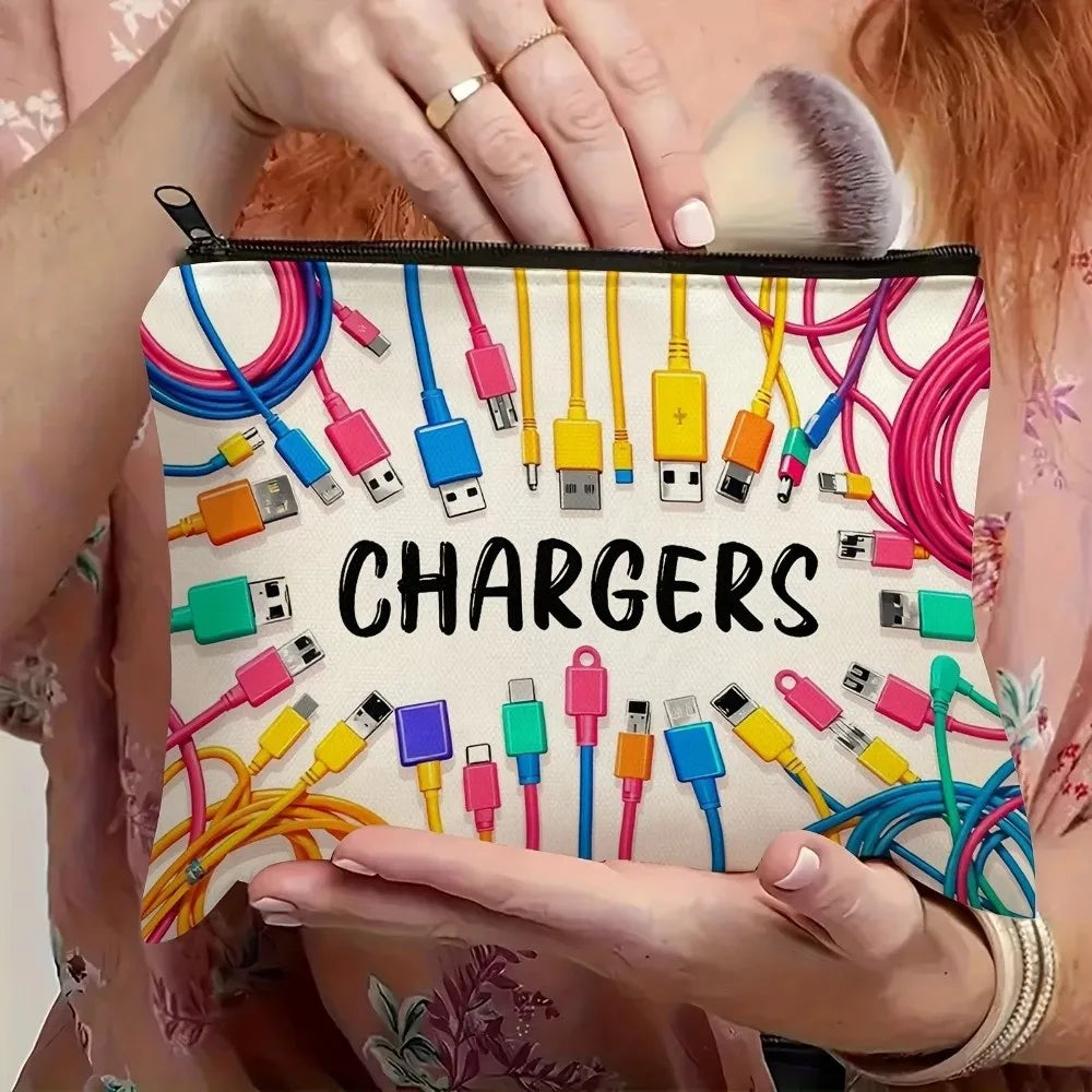 A hand holds a canvas charger storage pouch filled with various electronic chargers and cables.