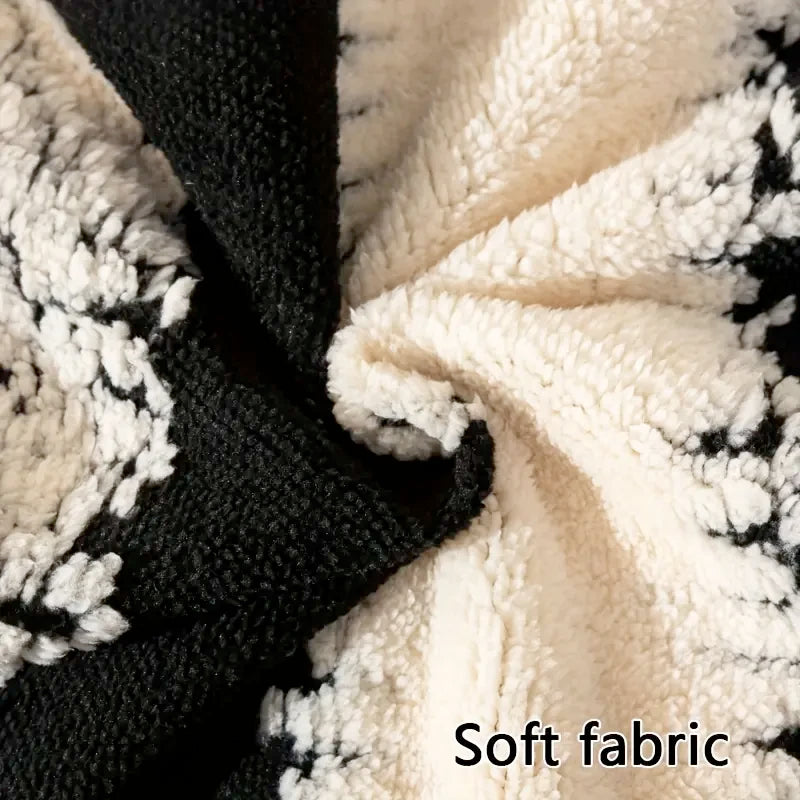 Close-up of a black and white soft knit fabric throw or sofa cover with a textured, fluffy appearance.