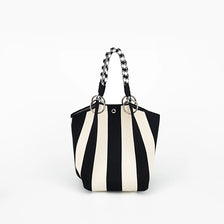 A black and white striped knitted tote bag with black leather handles.