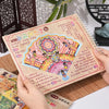 A hand holds a handmade notebook featuring colorful 3D sticker scenes of pocket cabins and landscapes for kids.
