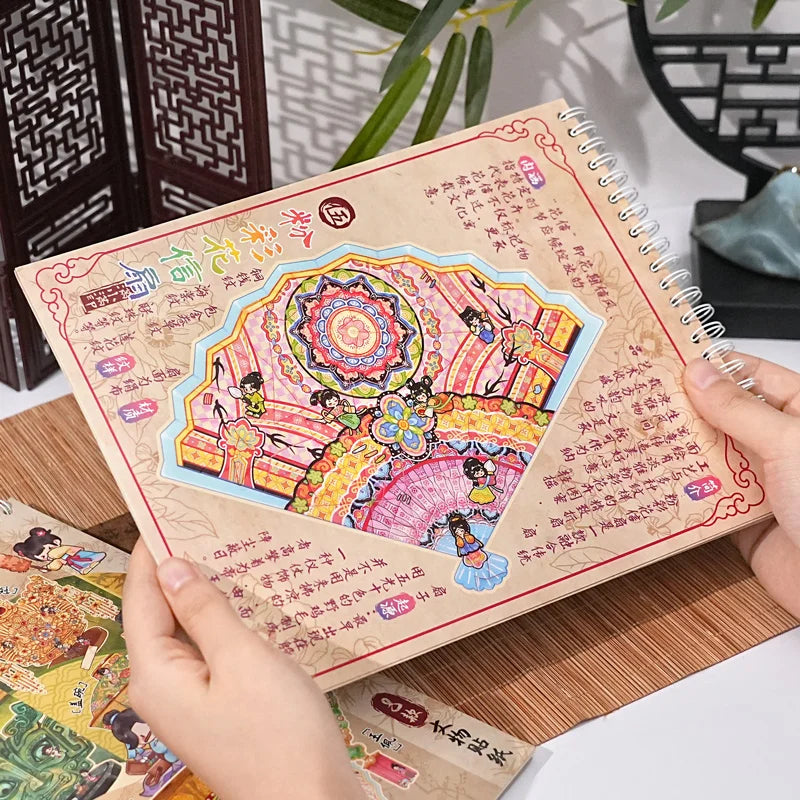 A hand holds a handmade notebook featuring colorful 3D sticker scenes of pocket cabins and landscapes for kids.