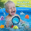 A baby is playing in a pool with various floating toys including a shark, turtle, and a blue net.