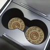 Close-up view of a car cup holder with two absorbent leather mats featuring a gauge and star pattern.