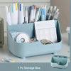 A light blue storage box filled with various pens, markers, and office supplies.