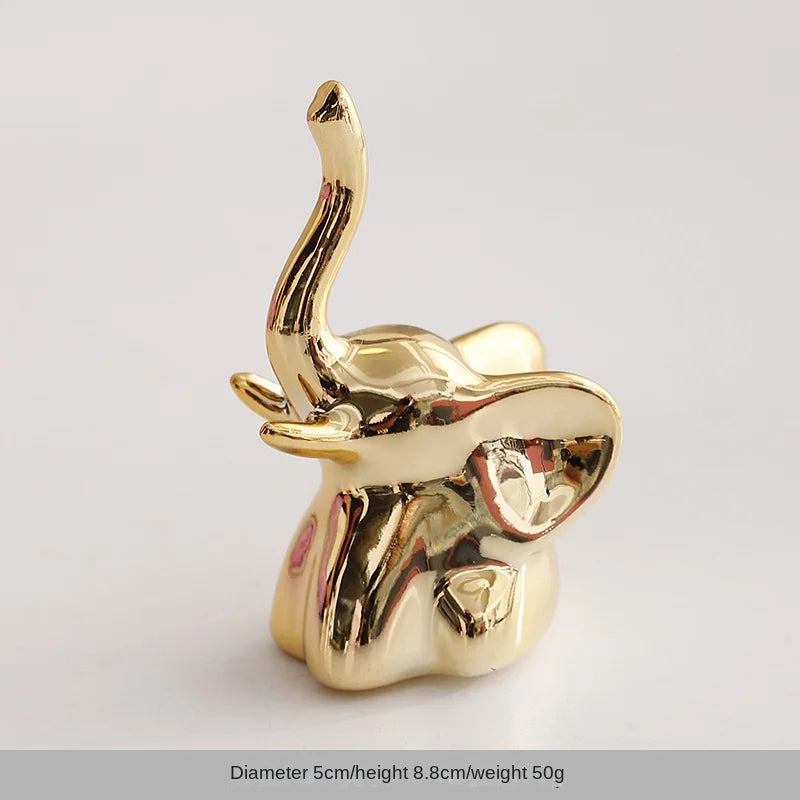 Gold-colored ceramic elephant and rabbit jewelry holder with a curved horn design
