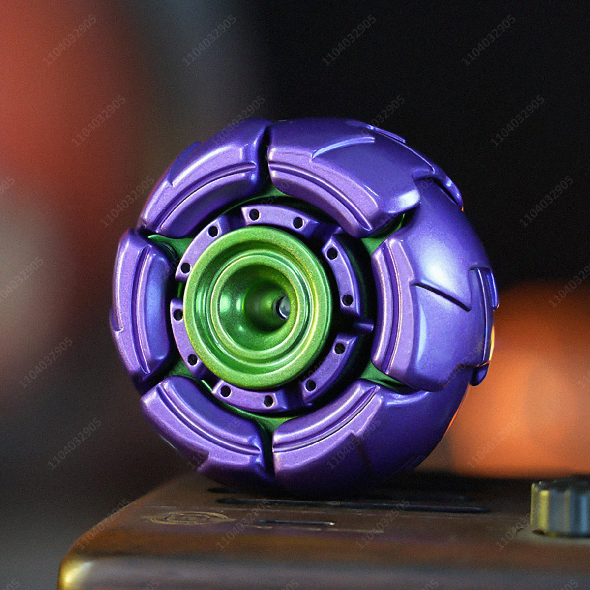 A purple fidget spinner with a green center is shown on a surface.