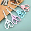 A set of five precision stainless steel scissors in pink and light blue colors resting on a brown paper background.