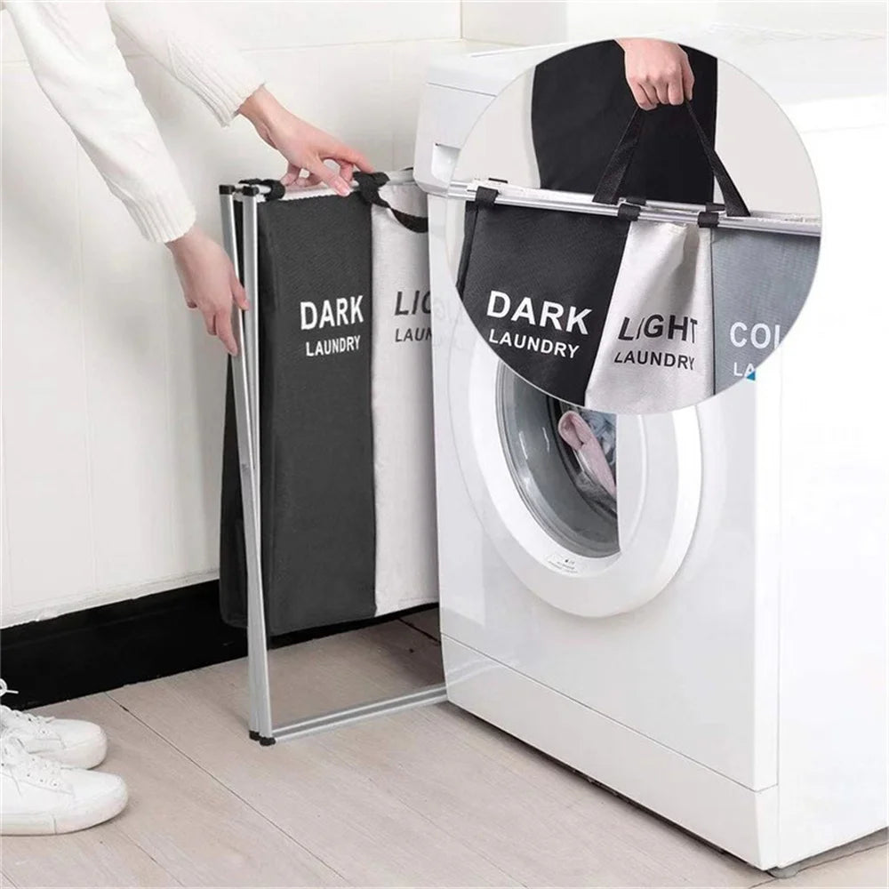 A person is loading a foldable waterproof laundry basket with handles and sorting compartments into a white washing machine.