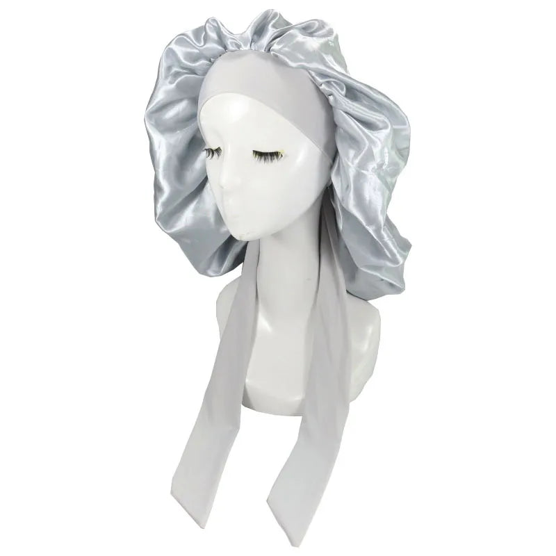 A white mannequin head wearing a silver satin sleep cap for hair protection
