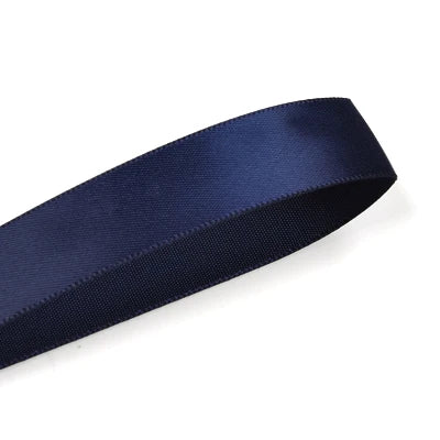 A dark navy blue satin ribbon roll shown diagonally against a white background.