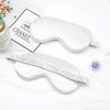 A white silk sleep mask with elastic straps is shown next to a box labeled CHANEL.