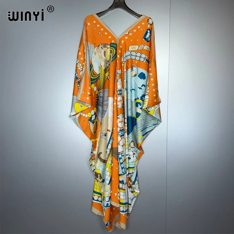 Orange-weißes Boho-Blumenmuster-Maxikleid hängt an einem Haken.