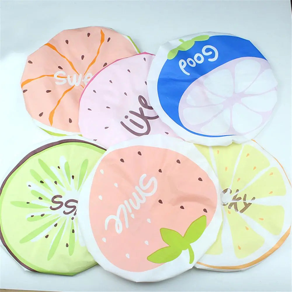 A collection of pink, orange, and green fruit-themed waterproof shower caps for women.