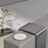 A close-up of a modern, rectangular organizer rack with a circular plate on top, set against a neutral gray background.