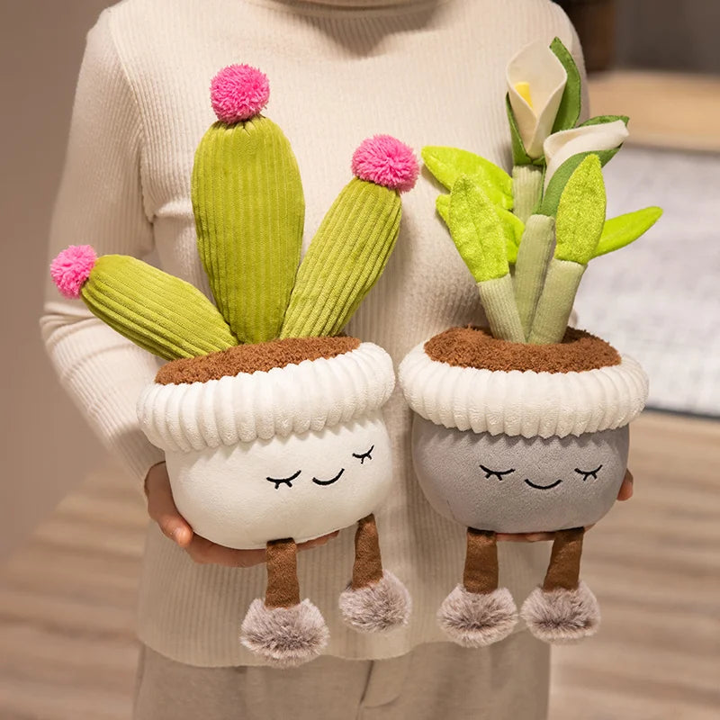 A hand holds a cute artificial flower plush doll featuring soft green cactus-like plants and pink pom-pom accents.