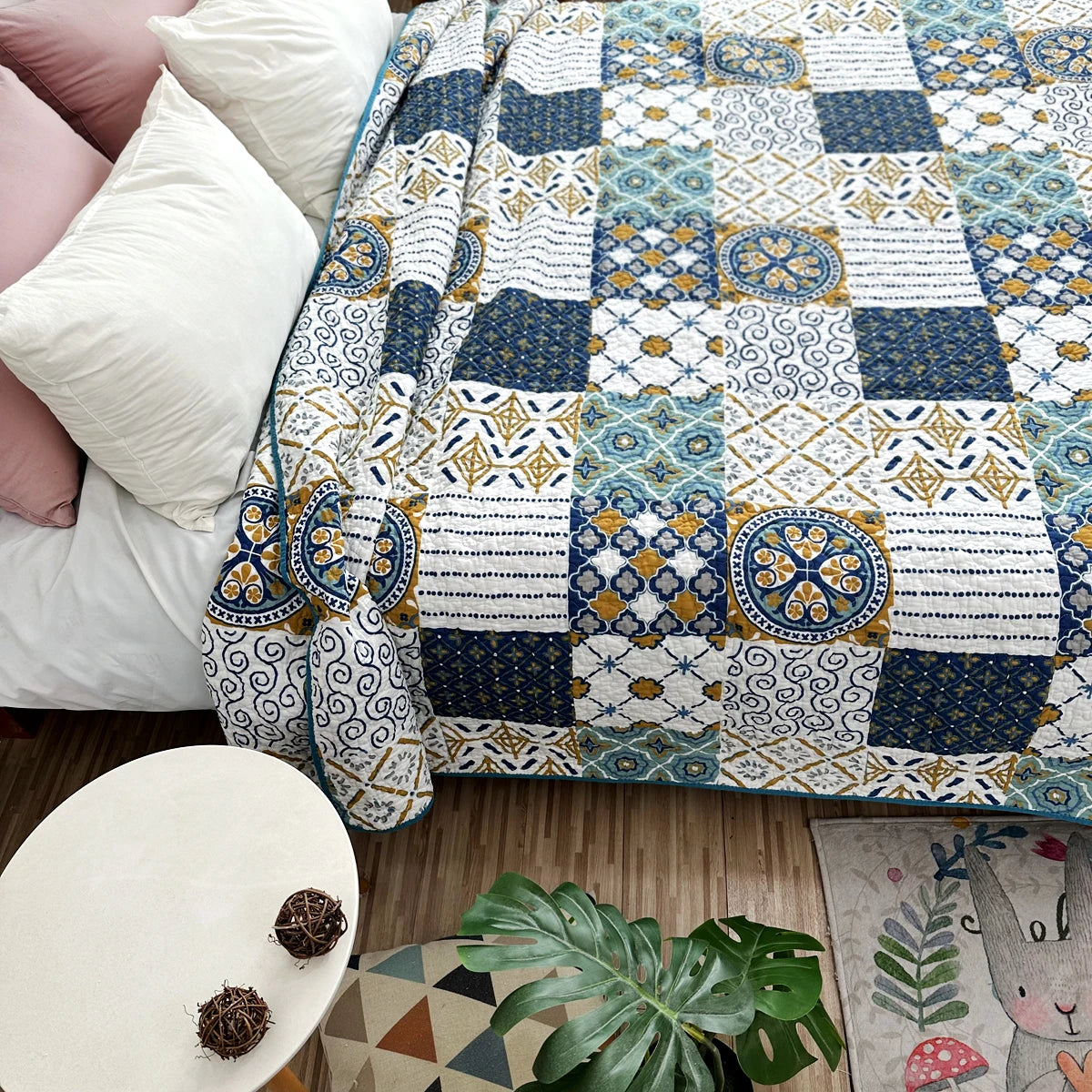 A pastoral patchwork cotton bedspread featuring blue, white, and yellow geometric patterns on a bed.