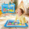 A baby is playing with an inflatable ocean-themed water play mat featuring colorful sea creatures and marine life.