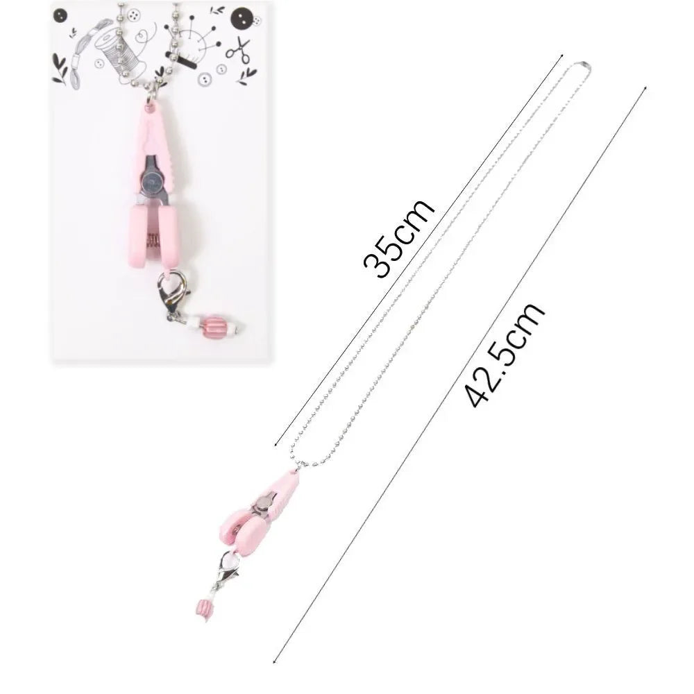 Pink precision mini scissors with a protective cover displayed against a white background.