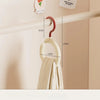 A wooden wall-mounted hook organizer for hats and scarves, showing various sizes and a beige fabric item.