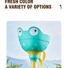 A cyan colored flying saucer toy is shown outdoors with green foliage in the background.