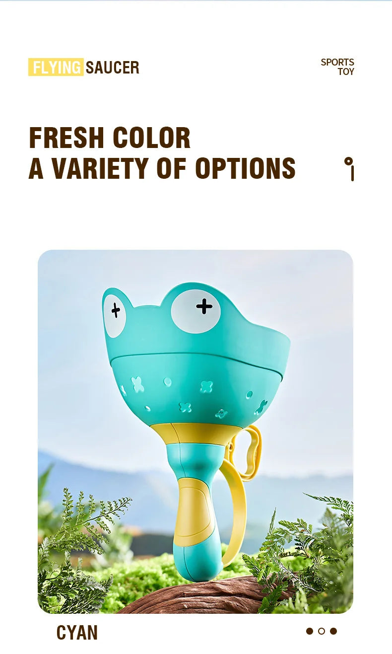 A cyan colored flying saucer toy is shown outdoors with green foliage in the background.