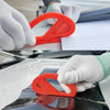 A hand wearing a white glove is using an orange vinyl wrap application tool on a surface.