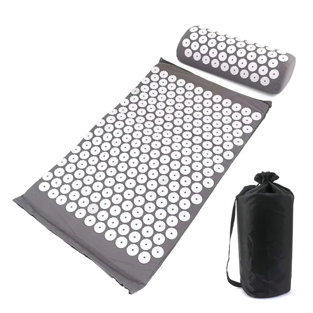 A dark gray acupressure mat and pillow set with numerous white dots for pain relief and relaxation.