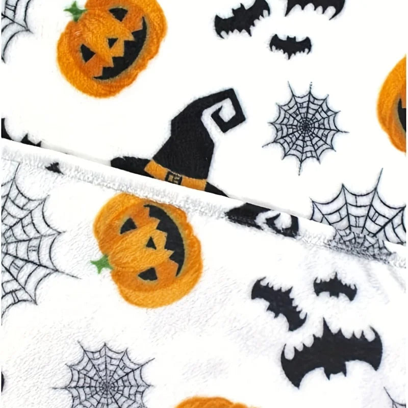 A white flannel throw blanket featuring a spooky Halloween print with orange pumpkins and black bats.
