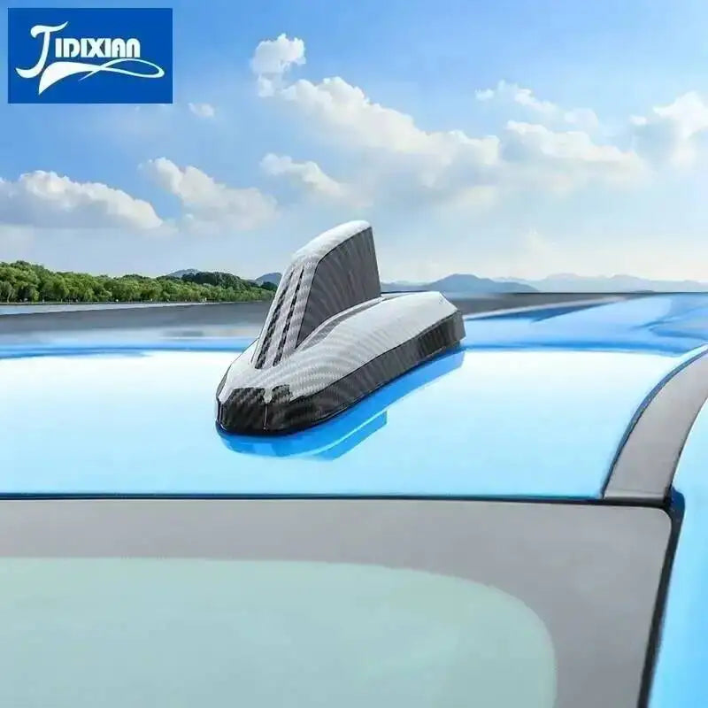 Chrome-style car antenna cover trim installed on a blue vehicle roof.