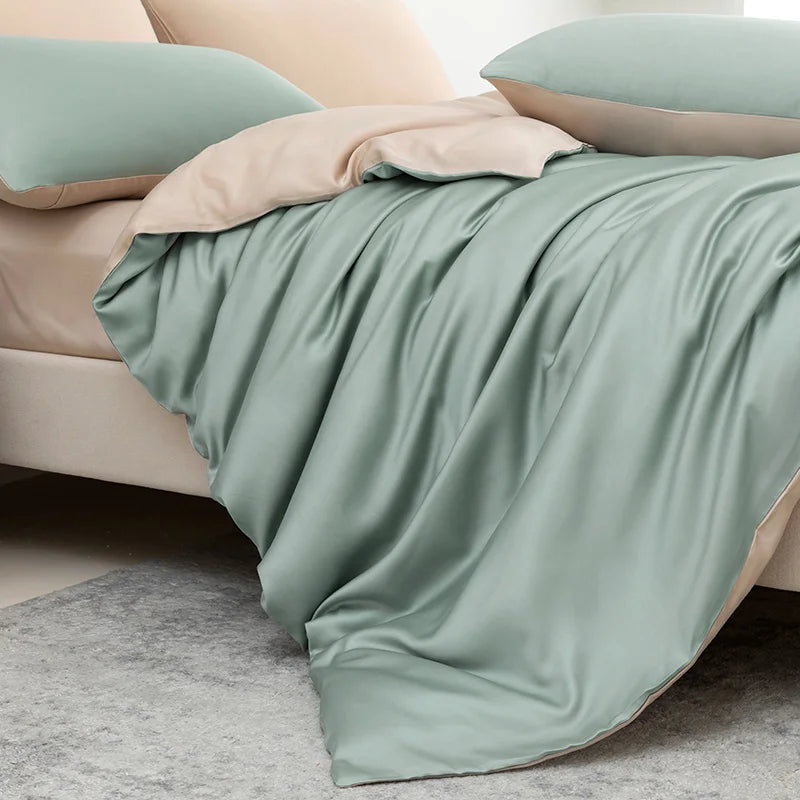 Luxuriöses Bambus-Deckenset in sanften Salbeigrün- und Beige-Tönen über einem Bett drapiert.