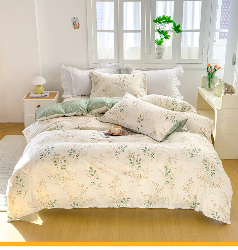 A white duvet cover set with a floral tea pattern featuring green and beige tones displayed on a bed.