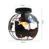 A black crystal single-head ceiling lamp with a metal frame and an amber light bulb.