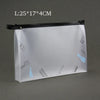 A transparent toiletry bag with a black zipper and hanging hooks is shown against a gray background.