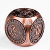 A bronze metal spinner dice cube featuring a dragon design on its face.
