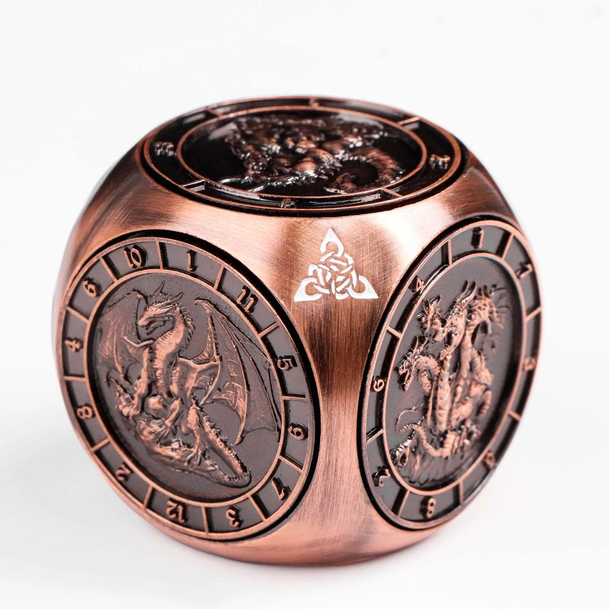A bronze metal spinner dice cube featuring a dragon design on its face.