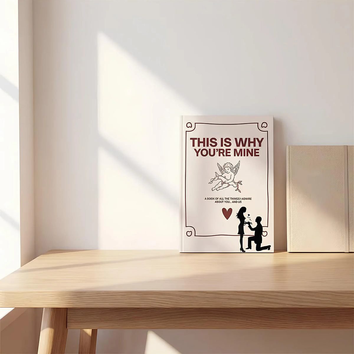 A white book with a title This is why you're mine and illustrations of a couple on the cover.