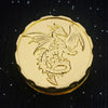 A gold metal fingertip gyro roulette dice for tabletop games with a winged creature design.