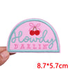 Pink embroidered patch with the text Howdy Darling in light blue thread and a red cherry design