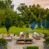 Weatherproof patio furniture cover shown on a wooden deck surrounded by lush greenery and trees.